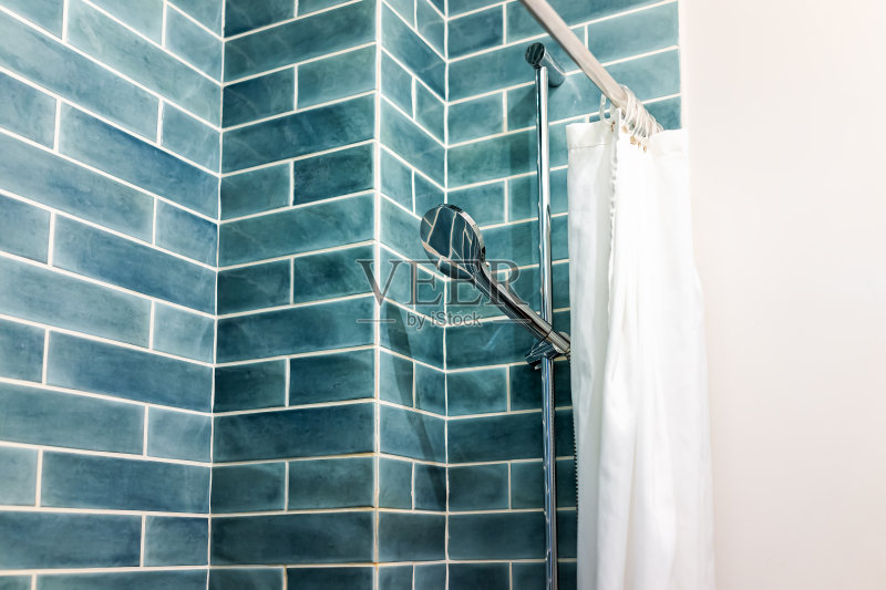 现代极简主义浴室与蓝色绿色瓷砖瓷砖淋浴和头在明亮的房间与窗帘正版图片素材