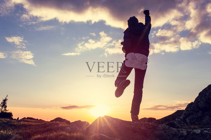 人生目标的概念。一个女人在美丽的日落前挥舞着他的拳头。正版图片素材