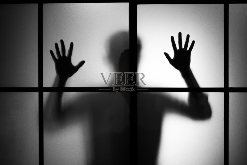 一个男人的剪影站在磨砂玻璃门后面正版图片素材