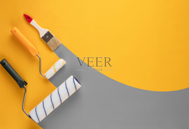 灰色条纹的油漆从滚轮和刷子在黄色的背景。正版图片素材