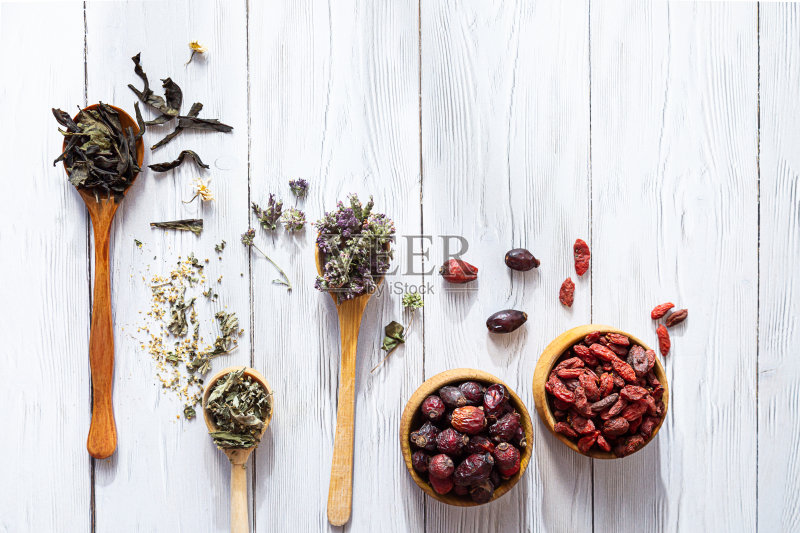 各种各样的花草茶。Chamaenerion，洋甘菊，玫瑰果，Origanum，枸杞和绣线菊放在白色的木桌上。天然草药。正版图片素材