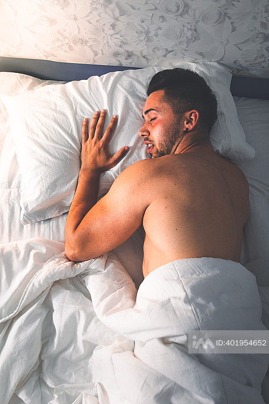 年轻性感的白人男人在床上从天顶的角度照片摄影图片